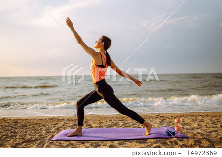 Young woman in sportswear doing yoga, fitness exerciseon the beach. Sport, Active life. Young woman in sportswear doing yoga, fitness exerciseon the beach. Sport, Active life. 114972369