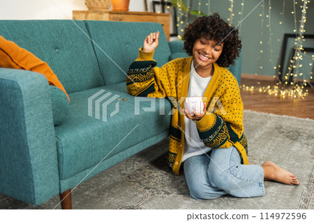Saving money investment for future. African American girl holding pink piggy bank and putting money coin. Saving investment budget business wealth retirement financial money banking concept 114972596