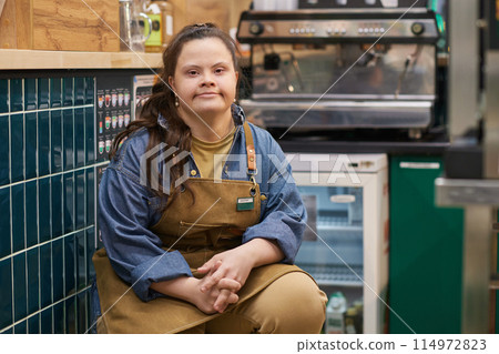 Portrait of independent adult woman with Down syndrome working in cafe and looking at camera with confidence copy space 114972823