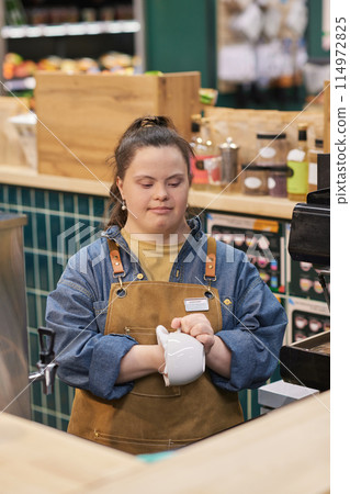Vertical portrait of young woman with disability working in cafe and cleaning coffee cups enjoying occupational training Vertical portrait of young woman with disability working in cafe and cleaning coffee cups enjoying occupational training 114972825