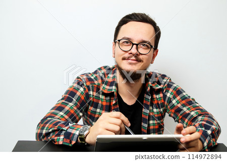 Young man with tablet. A young man using modern technology, digital lifestyle, business and communication, education and learning, remote work and connectivity 114972894