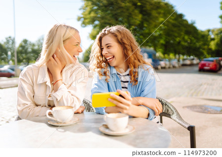 Two young women sitting in the cafe. Coffee break after shopping. Blogging, tourism. Two young women sitting in the cafe. Coffee break after shopping. Blogging, tourism. 114973200