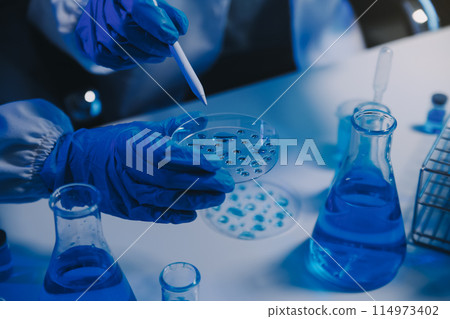 chemist,scientist hand dropping chemical liquid into test tube, science research and development concept chemist,scientist hand dropping chemical liquid into test tube, science research and development concept 114973402