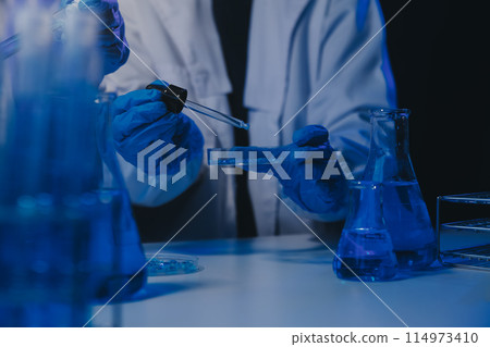 chemist,scientist hand dropping chemical liquid into test tube, science research and development concept chemist,scientist hand dropping chemical liquid into test tube, science research and development concept 114973410