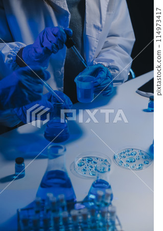chemist,scientist hand dropping chemical liquid into test tube, science research and development concept 114973417