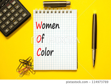 WOC women of color symbol. Concept words WOC women of color on beautiful white note. Beautiful yellow background. Black calculator. Business WOC women of color social issues concept. Copy space. 114973789