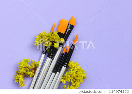 a set of brushes for painting with flowers on a lilac background. synthetic brushes for watercolor, gouache, acrylic. 114974363
