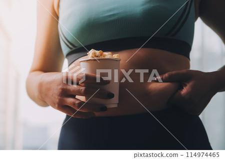 A woman holding a bowl of popcorn 114974465