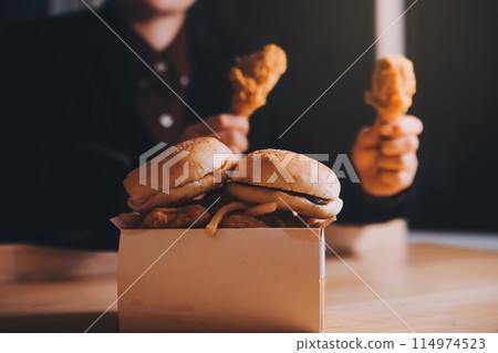 close up focus woman hand hold fried chicken for eat,girl with fast food concept close up focus woman hand hold fried chicken for eat,girl with fast food concept 114974523