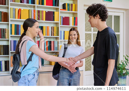 Meeting of classmates in high school library, teenagers shaking hands and greeting them 114974611