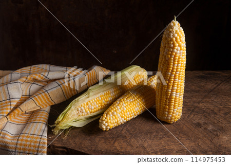 Several cobs sweet corn on wooden background.. Several cobs sweet corn on wooden background.. 114975453