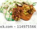 Cutting board with bunch of organic pink grapes on white wooden background.. 114975566