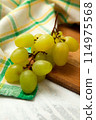Cutting board with bunch of organic green grapes on white wooden background.. 114975568