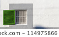 Bright Green Shutter on a White-Washed Wall in a Mediterranean Setting 114975866