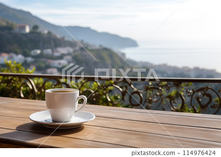 A cup of coffee on wooden table with view of the ocean A cup of coffee on wooden table with view of the ocean 114976424