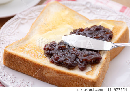 Spread bean paste on the bean-paste butter toast with a butter knife Spread bean paste on the bean-paste butter toast with a butter knife 114977554