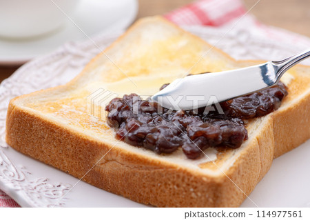 Spread bean paste on the bean-paste butter toast with a butter knife Spread bean paste on the bean-paste butter toast with a butter knife 114977561