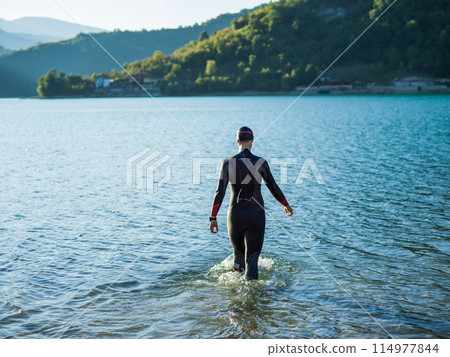 A triathlon swimmer preparing for a river training to gear up for a marathon 114977844