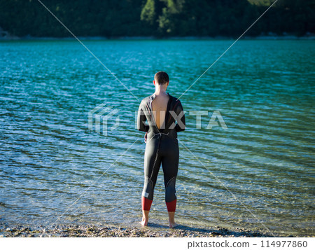 A triathlon swimmer preparing for a river training to gear up for a marathon 114977860