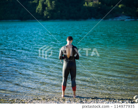 A triathlon swimmer preparing for a river training to gear up for a marathon 114977935