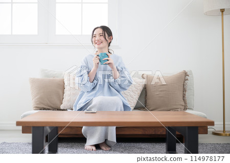 一位女士在客廳喝咖啡或飲料放鬆身心 114978177