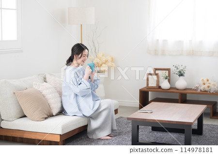 一位女士在客廳喝咖啡或飲料放鬆身心 114978181