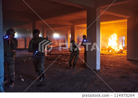 A group of professional soldiers bravely executes a dangerous rescue mission, surrounded by fire in a perilous building. 114978264