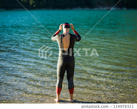 A triathlon swimmer preparing for a river training to gear up for a marathon A triathlon swimmer preparing for a river training to gear up for a marathon 114978321
