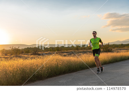 Triathlete in professional gear running early in the morning, preparing for a marathon, dedication to sport and readiness to take on the challenges of a marathon. Triathlete in professional gear running early in the morning, preparing for a marathon, dedication to sport and readiness to take on the challenges of a marathon. 114978570