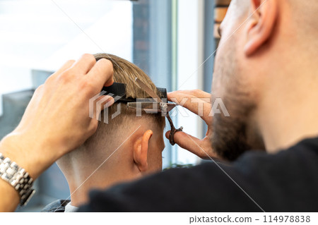 Hairdresser's hands making hairstyle to little boy, close up 114978838