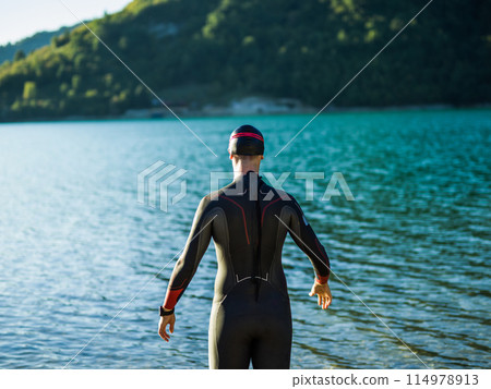 A triathlon swimmer preparing for a river training to gear up for a marathon A triathlon swimmer preparing for a river training to gear up for a marathon 114978913
