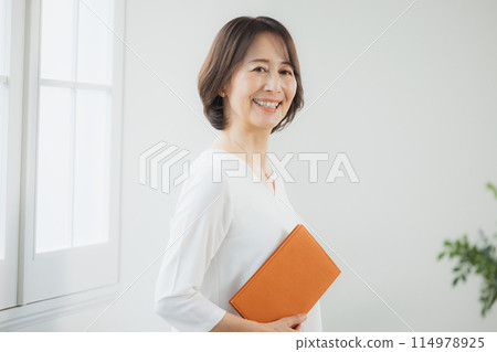 Middle-aged woman working remotely Middle-aged woman working remotely 114978925