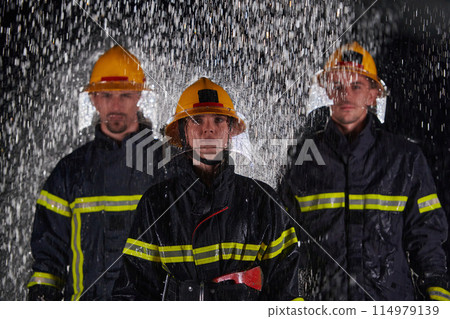A group of professional firefighters marching through the rainy night on a rescue mission, their determined strides and fearless expressions reflecting their unwavering bravery and unwavering 114979139