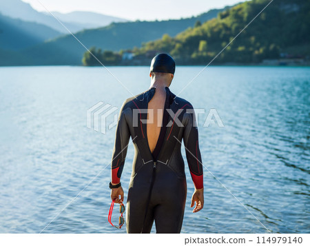 A triathlon swimmer preparing for a river training to gear up for a marathon A triathlon swimmer preparing for a river training to gear up for a marathon 114979140