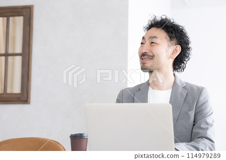 Bearded middle-aged man using a computer Bearded middle-aged man using a computer 114979289