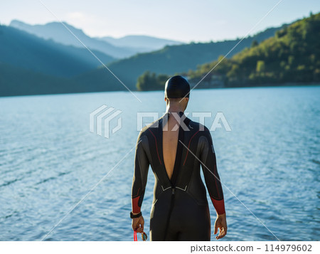 A triathlon swimmer preparing for a river training to gear up for a marathon 114979602
