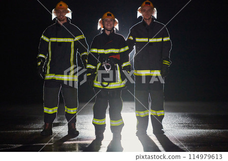 A group of professional firefighters marching through night on a rescue mission, their determined strides and fearless expressions reflecting their unwavering bravery and unwavering commitment to A group of professional firefighters marching through night on a rescue mission, their determined strides and fearless expressions reflecting their unwavering bravery and unwavering commitment to 114979613