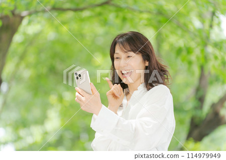 Middle woman operating a smartphone 114979949
