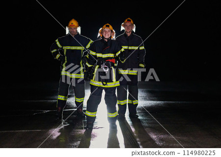 A group of professional firefighters marching through night on a rescue mission, their determined strides and fearless expressions reflecting their unwavering bravery and unwavering commitment to 114980225