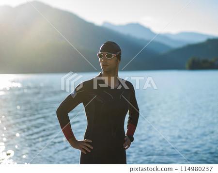 A triathlon swimmer preparing for a river training to gear up for a marathon A triathlon swimmer preparing for a river training to gear up for a marathon 114980237