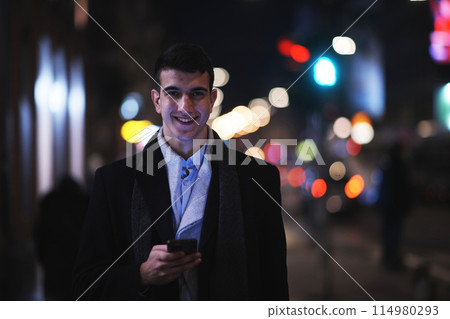 Smiling Meedle Eastern man walking down street near modern office building, 114980293