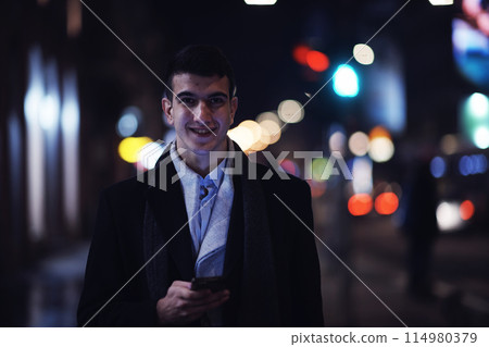 Smiling Meedle Eastern man walking down street near modern office building, Smiling Meedle Eastern man walking down street near modern office building, 114980379