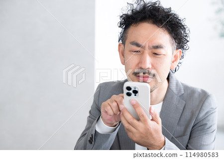 一名男子因看智慧型手機而患上老花眼 一名男子因看智慧型手機而患上老花眼 114980583