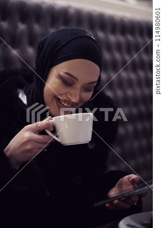 happy Middle Eastern female having break take a cup of tea in restaurant happy Middle Eastern female having break take a cup of tea in restaurant 114980601