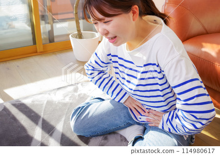 A woman suffering from abdominal pain 114980617