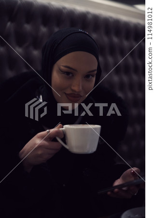 happy Middle Eastern female having break take a cup of tea in restaurant happy Middle Eastern female having break take a cup of tea in restaurant 114981012