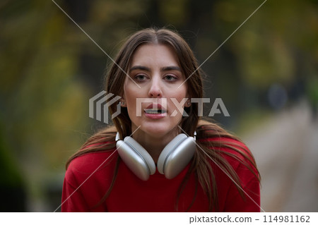 Athletic young woman taking a breath and relaxing after jogging and stretching. Woman Training and Workout Exercises On Street. 114981162