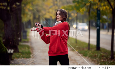 Athletic young woman taking a breath and relaxing after jogging and stretching. Woman Training and Workout Exercises On Street. 114981168