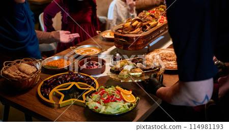 In this captivating aerial view, delicious food adorned with Ramadan decorations, including dates and meat, awaits the arrival of an European Islamic family, promising a festive and flavorful iftar In this captivating aerial view, delicious food adorned with Ramadan decorations, including dates and meat, awaits the arrival of an European Islamic family, promising a festive and flavorful iftar 114981193