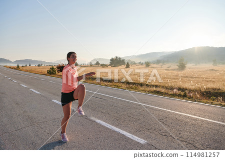 Determined Stretch: Athletic Woman Embraces Post-Run Flexibility in Nature. 114981257